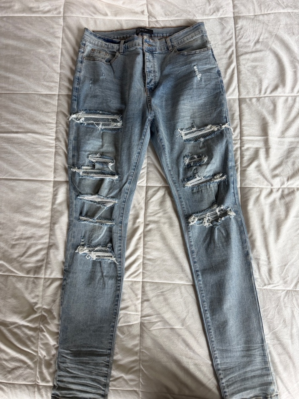 AMIRI distressed light wash men’s skinny jeans